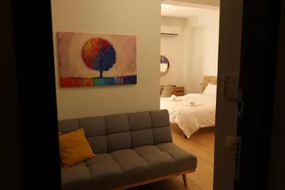 a living room with a couch and a painting on the wall at Urban Charming Studio for 3 by MPS in Athens