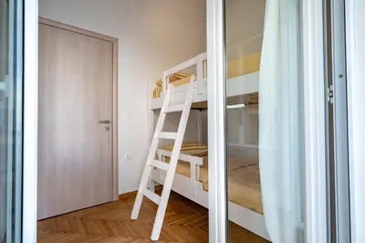a white bunk bed in a small room with a ladder at Athens Center 2 BDR Family Apartment at Zografou ! in Athens