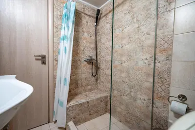 a bathroom with a shower with a glass door at Athens Center 2 BDR Family Apartment at Zografou ! in Athens