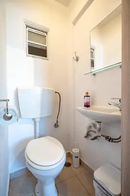 a white bathroom with a toilet and a sink at Athens Center 2 BDR Family Apartment at Zografou ! in Athens