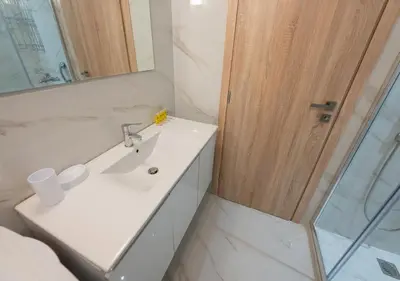 a bathroom with a white sink and a shower at Modern flat 7' from Subway Stations in Athens