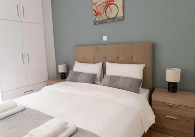 a bedroom with a large white bed with two pillows at Modern flat 7' from Subway Stations in Athens