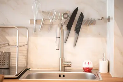 a kitchen sink with utensils hanging on a wall at City Wanderer Modern Loft in Athens