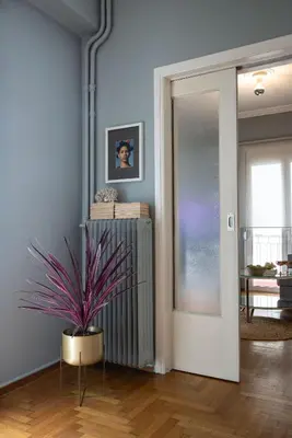 a living room with a potted plant and a mirror at Bonjour Athens in Athens
