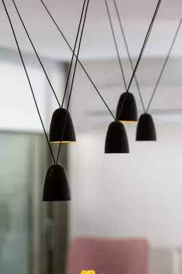 a row of black lights hanging from a ceiling at Award-winning apartments in Athens