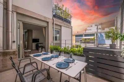 a table and chairs on a balcony with a painting at Award-winning apartments in Athens