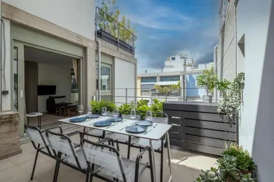 a patio with a table and chairs on a balcony at Award-winning apartments in Athens