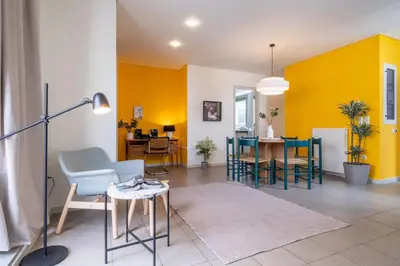 a living room with yellow walls and a table and chairs at Award-winning apartments in Athens