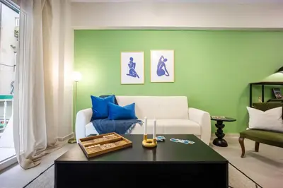 a living room with a white couch and blue pillows at Modern Central Apartment with Balcony - Near Metro in Athens