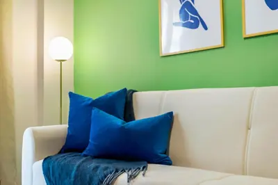 a living room with a white couch with blue pillows at Modern Central Apartment with Balcony - Near Metro in Athens
