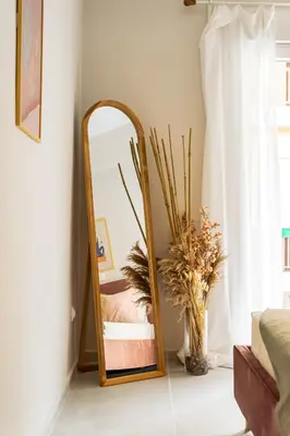 a mirror in a room with a vase of flowers at Modern Central Apartment with Balcony - Near Metro in Athens