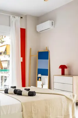 a bedroom with a bed and a mirror at Modern Central Apartment with Balcony - Near Metro in Athens