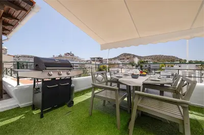 a grill on a balcony with a table and chairs at Central penthouse studio with Jacuzzi in Varkiza in Vari