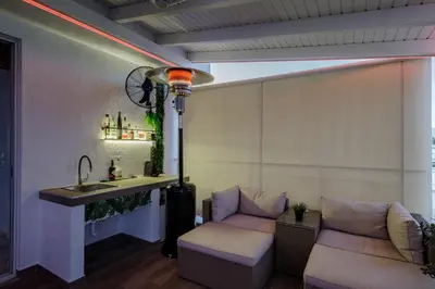 a living room with a sink and a couch at Central penthouse studio with Jacuzzi in Varkiza in Vari