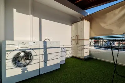 a laundry room with a washer and dryer at Central penthouse studio with Jacuzzi in Varkiza in Vari