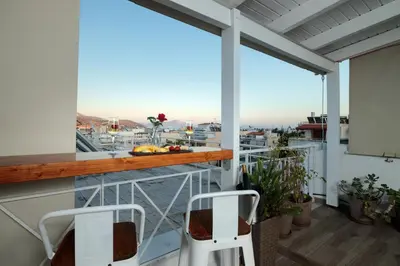 a balcony with two chairs and a view of the city at Central penthouse studio with Jacuzzi in Varkiza in Vari