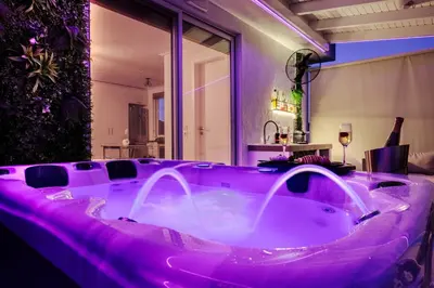 a hot tub in a room with purple lighting at Central penthouse studio with Jacuzzi in Varkiza in Vari