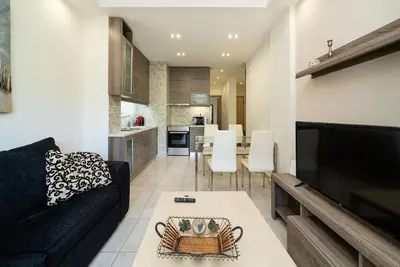 a living room with a black couch and a table at Acropolis Nest in Athens