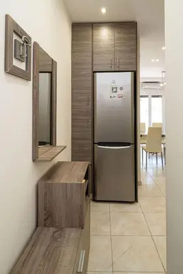 a kitchen with a stainless steel refrigerator and a table at Acropolis Nest in Athens