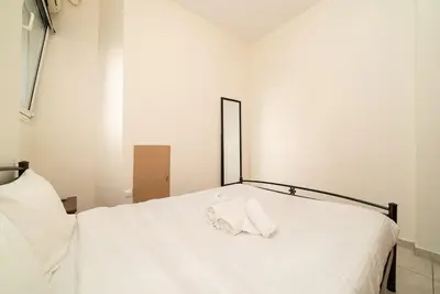 a white bed with a white towel on it at Acropolis Nest in Athens