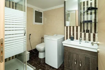 a bathroom with a toilet and a sink and a mirror at Acropolis Nest in Athens