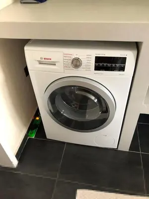 a white washing machine in a kitchen under a counter at Luxurious apartment with big balconyBEST location in Athens