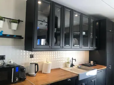 a kitchen with black cabinets and a sink at Luxurious apartment with big balconyBEST location in Athens