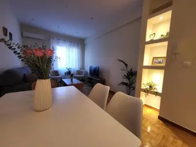 a living room with a white table with a vase of flowers at 2 bd renovated flat at acropolis in Athens
