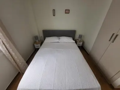 a bed in a small room with two night stands at 2 bd renovated flat at acropolis in Athens