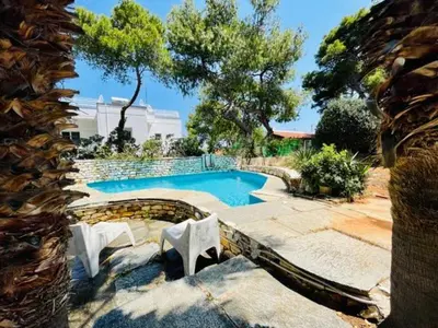 a swimming pool in a yard with two white chairs at Villa Pharaoh Private Pool Near the Beach in Porto Rafti