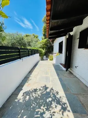 a walkway next to a white building with a fence at Villa Pharaoh Private Pool Near the Beach in Porto Rafti