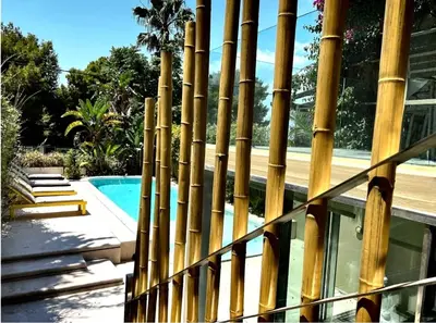 a bamboo fence next to a swimming pool at VILLA LAGUNA BLUE - Kavouri Vouliagmeni BEACH FRONT in Athens