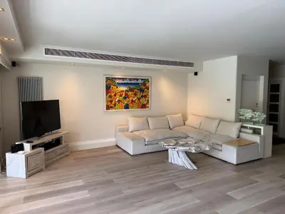 a living room with a white couch and a tv at VILLA LAGUNA BLUE - Kavouri Vouliagmeni BEACH FRONT in Athens