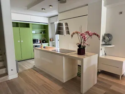 a kitchen with green cabinets and a counter with flowers on it at VILLA LAGUNA BLUE - Kavouri Vouliagmeni BEACH FRONT in Athens