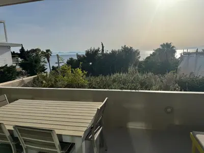 a table and chairs on the balcony of a house at VILLA LAGUNA BLUE - Kavouri Vouliagmeni BEACH FRONT in Athens