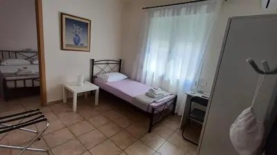 a small room with a small bed and a window at Armonia's Apartment in Piraeus