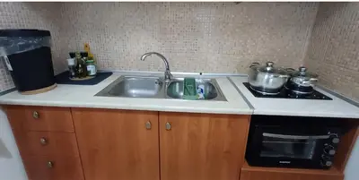 a kitchen with a sink and a stove with pots and pans at Armonia's Apartment in Piraeus