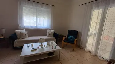 a living room with a couch and a table at Armonia's Apartment in Piraeus