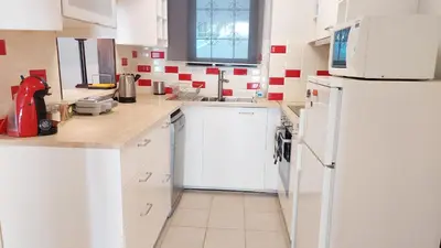 a kitchen with white cabinets and a white refrigerator at COZY Apt BY THE SEA AT VOULIAGMENI in Athens