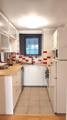 a large kitchen with white cabinets and a window at COZY Apt BY THE SEA AT VOULIAGMENI in Athens