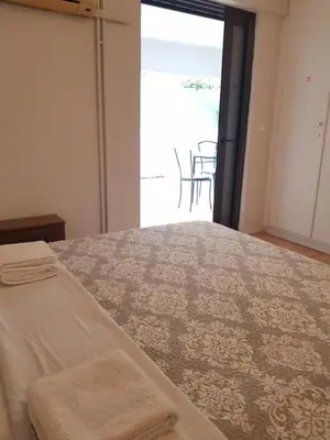 a bedroom with a bed with a view of a patio at COZY Apt BY THE SEA AT VOULIAGMENI in Athens