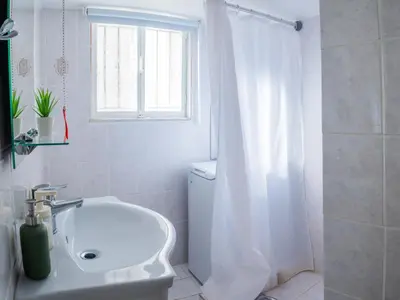 a white bathroom with a tub and a sink at Acropolis Sunny Flat in Athens
