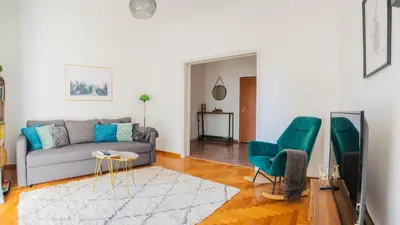 a living room with a couch and two green chairs at Acropolis Sunny Flat in Athens