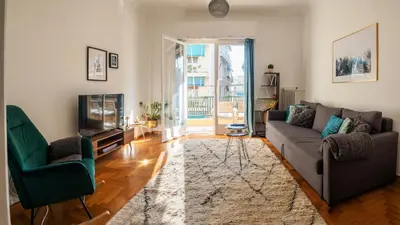 a living room with a couch and chairs and a television at Acropolis Sunny Flat in Athens