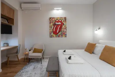 a bedroom with a white bed with a painting on the wall at 