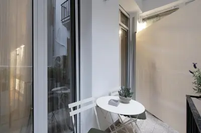 a small white table on a balcony with a window at 