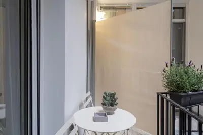 a small white table with a plant on a balcony at 