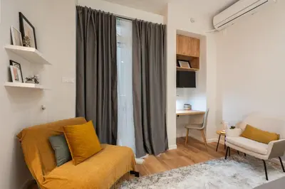 a living room with a couch and a chair and a desk at 