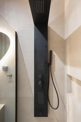 a shower in a bathroom with a black wall at 