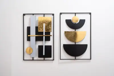 a trio of black and gold objects on a wall at 